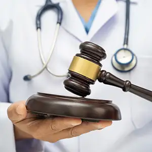 Doctor holding judge gavel, forensic medicine, medical law and crime justice.