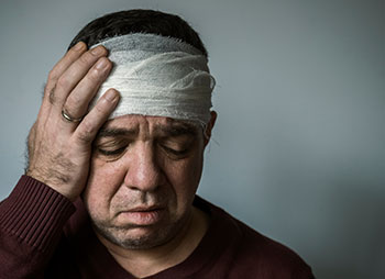 Injured man with head bandage for PTSD personal injury claim in Illinois.