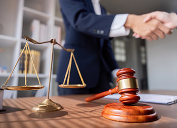 Scales of Justice, gavel, and handshake for Illinois personal injury case going to mediation